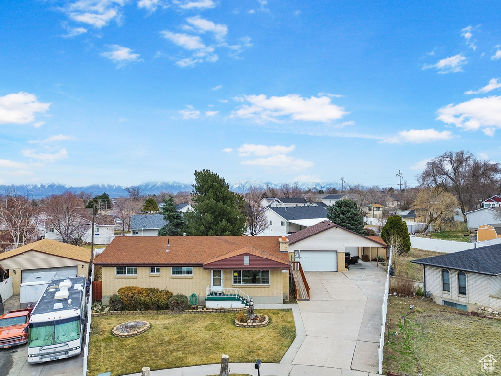 Single story home featuring a garage, a residential view, and a front lawn