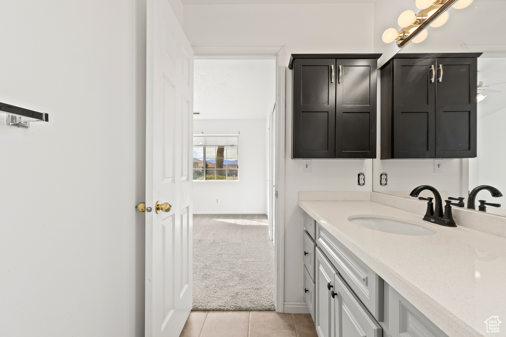 Bathroom with vanity, baseboards, and tile patterned floors