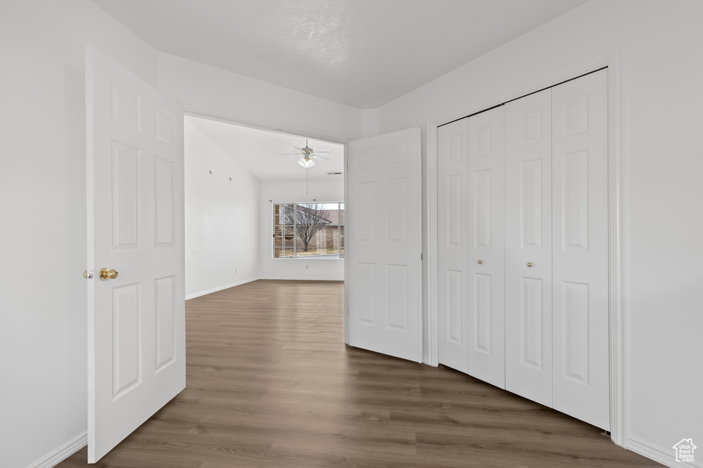 Unfurnished bedroom with a closet, baseboards, and wood finished floors