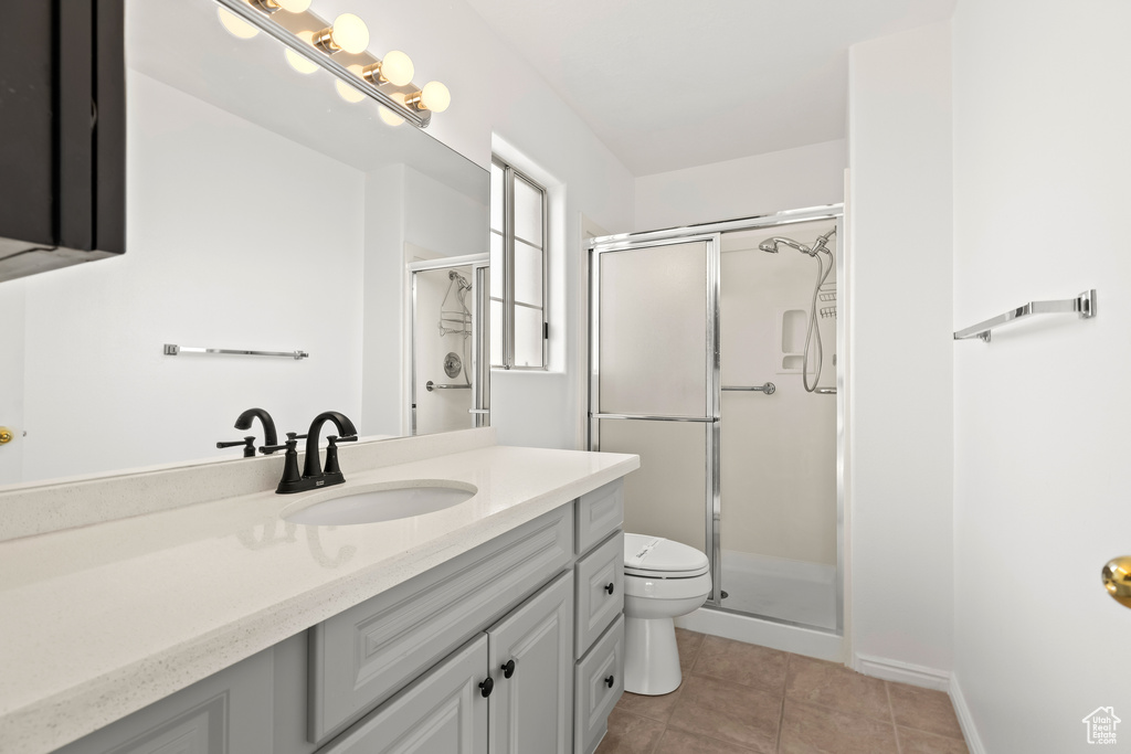 Bathroom with tile patterned flooring, a shower stall, toilet, and vanity