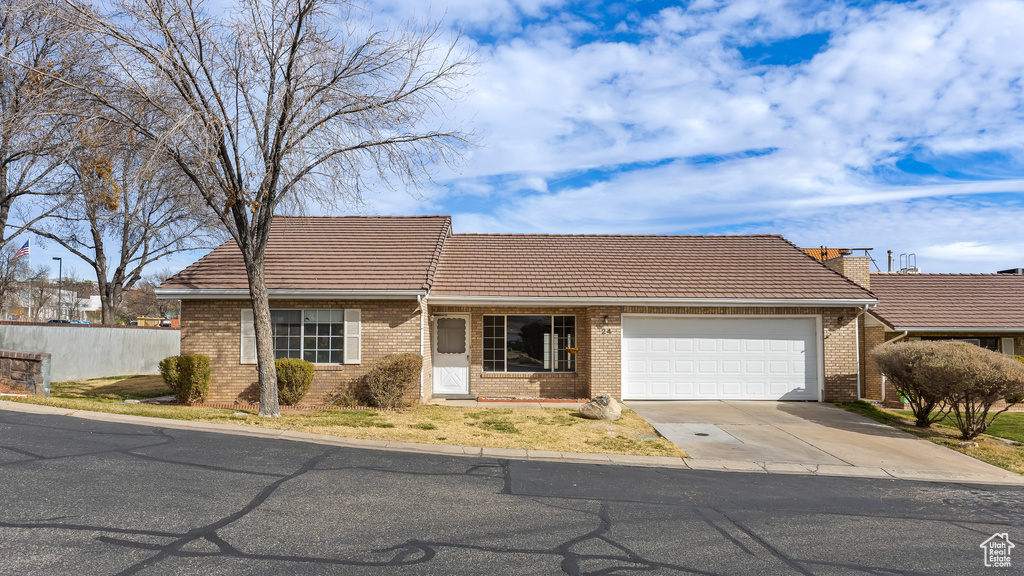 Ranch-style house featuring a garage, driveway, a tiled roof, fence, and brick siding