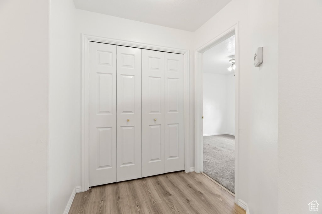 Hall with light wood-type flooring and baseboards