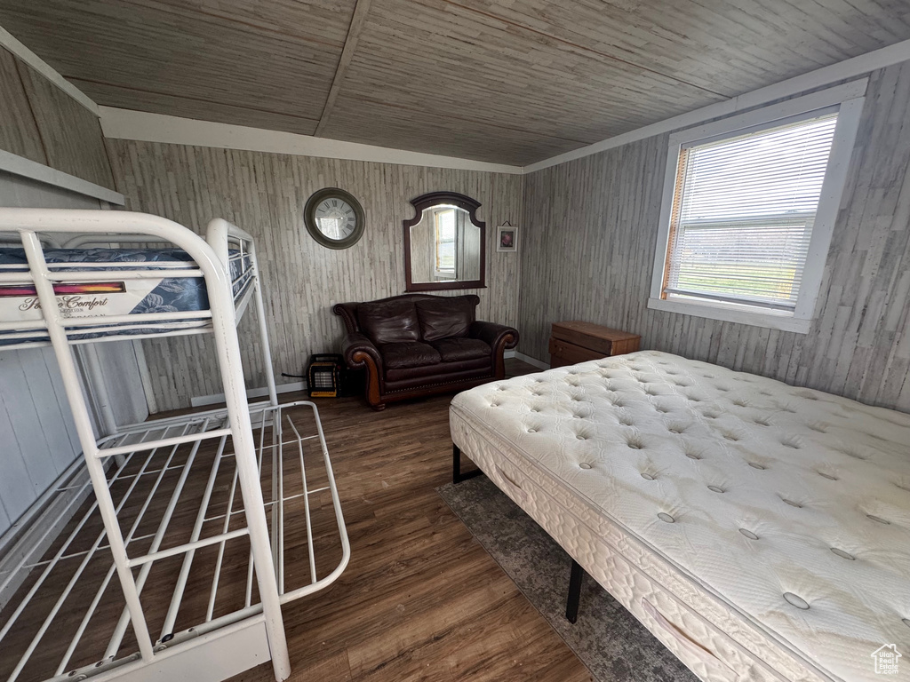 Bedroom with wood finished floors, wooden ceiling, and wooden walls