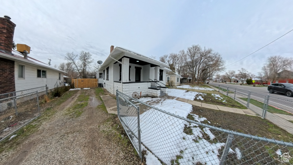 View of side of property featuring a fenced backyard and a gate