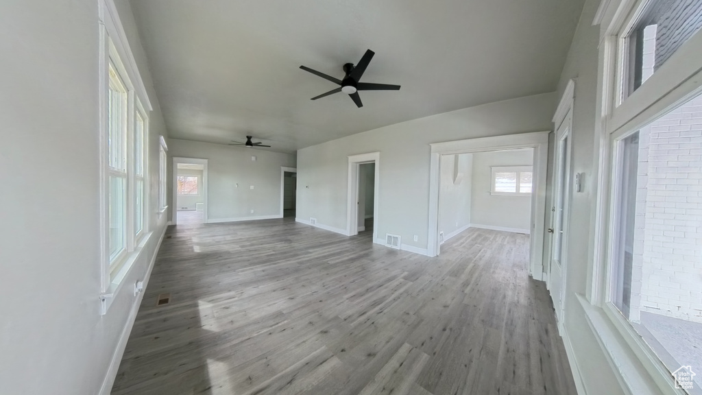 Empty room featuring baseboards, ceiling fan, visible vents, and light wood finished floors
