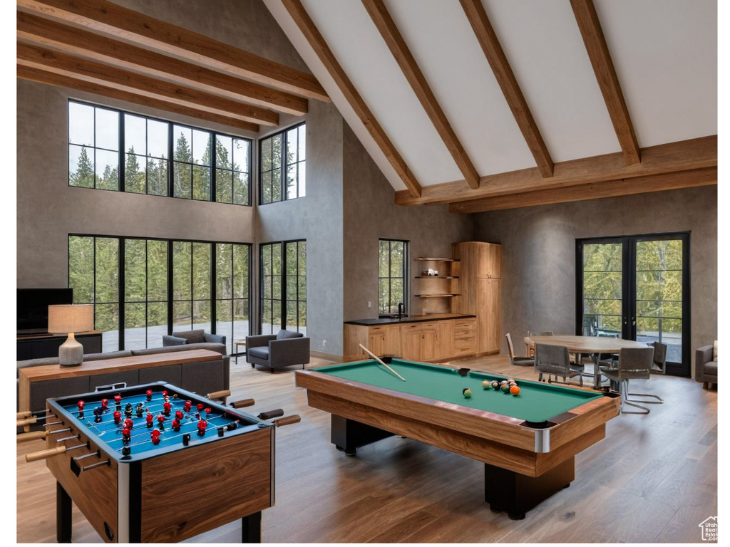 Playroom with high vaulted ceiling, wood finished floors, beam ceiling, billiards table, and french doors