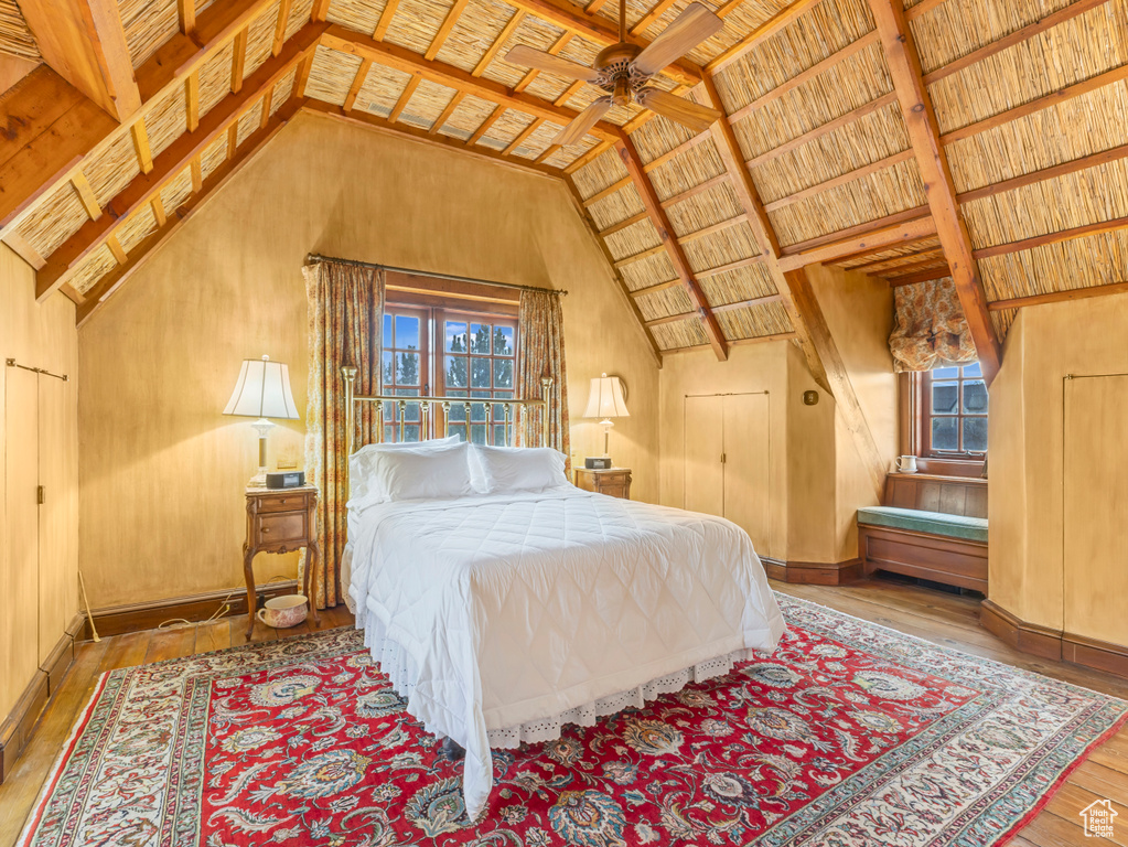 Bedroom with multiple windows, wood-type flooring, wood ceiling with exposed beams, and high vaulted ceiling