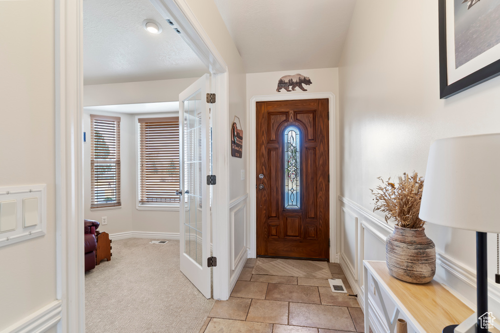 Entryway featuring visible vents and light colored carpet