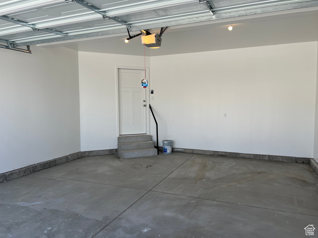 Garage featuring baseboards and a garage door opener