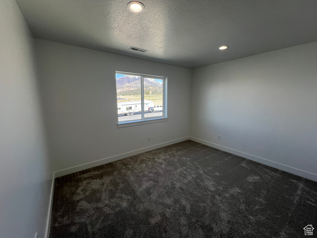 Unfurnished room with recessed lighting, visible vents, dark carpet, a textured ceiling, and baseboards