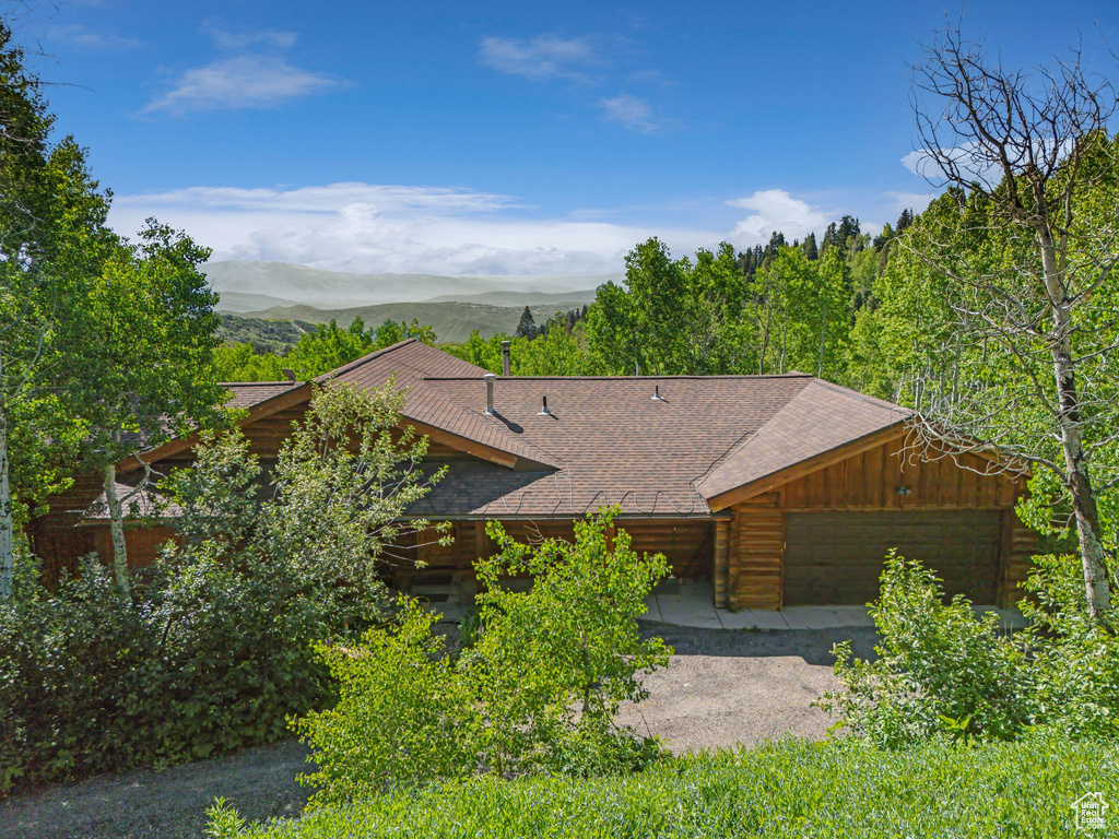 View of front of property with a mountain view and a shingled roof