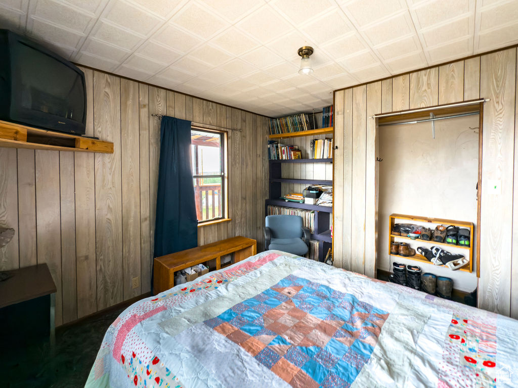 Bedroom featuring wood walls