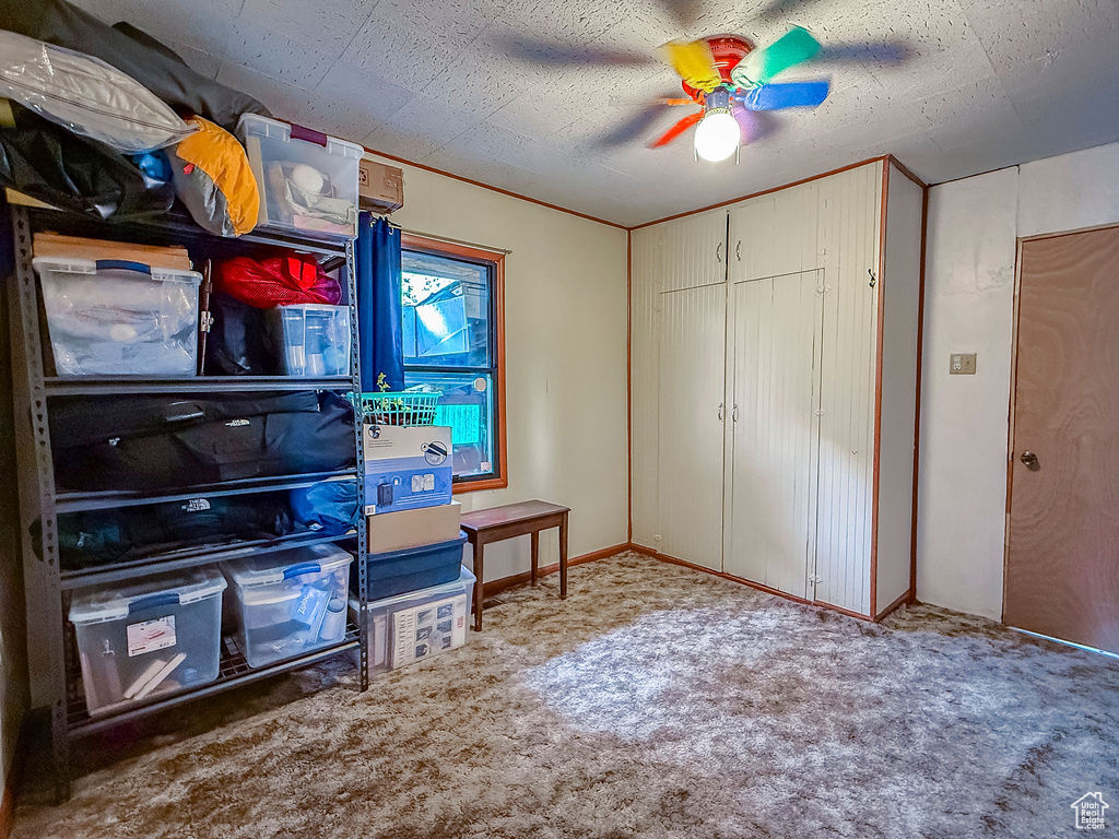 Carpeted bedroom featuring ceiling fan