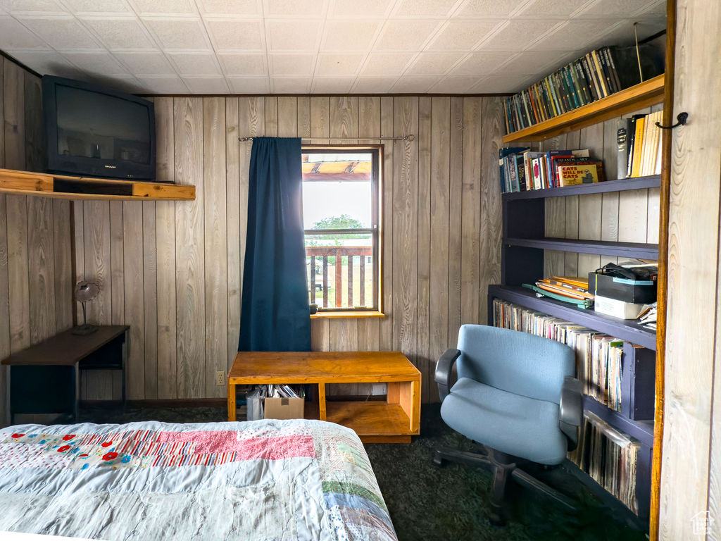 Bedroom featuring wood walls and carpet flooring