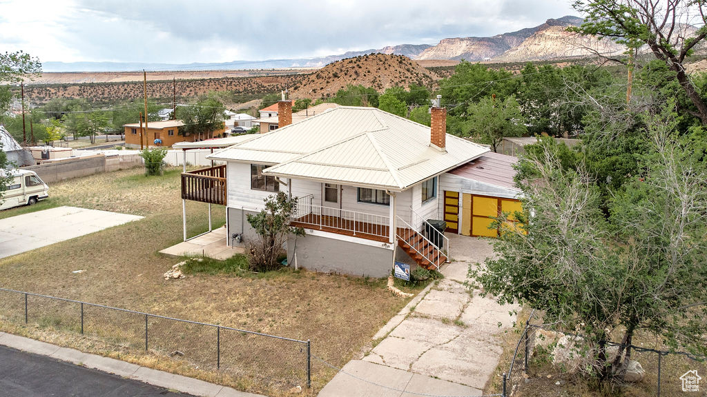 View of front of home featuring a chimney, a mountain view, and a metal roof