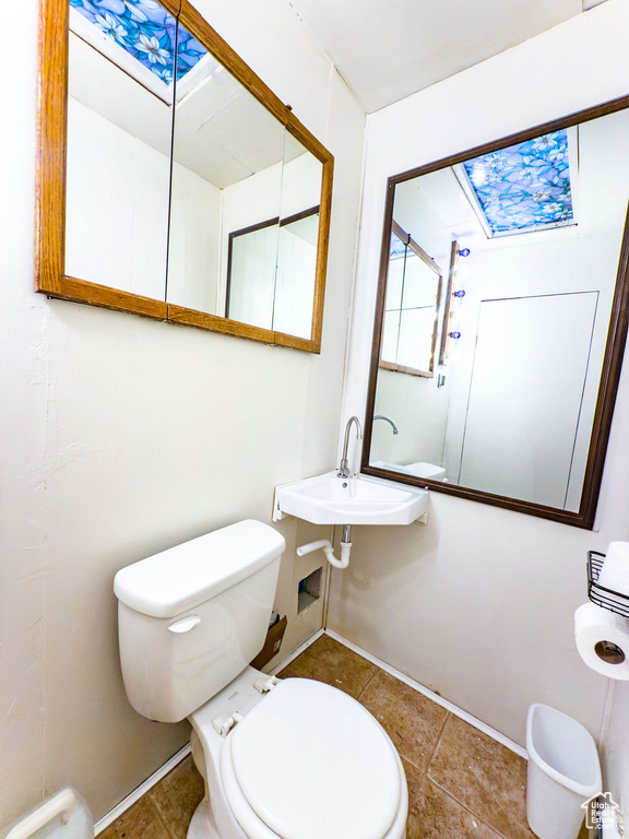 Bathroom with a skylight and tile patterned flooring