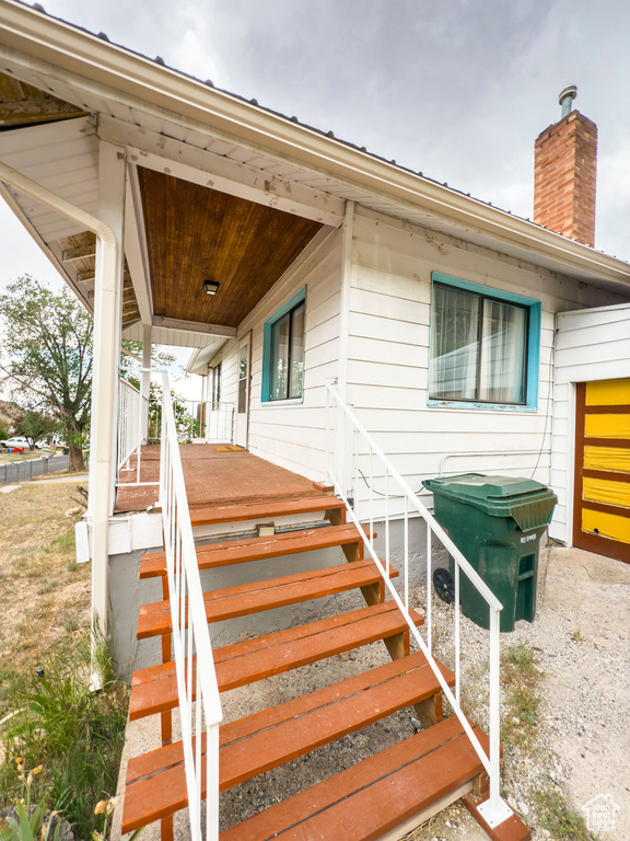 Property entrance featuring a porch and a chimney