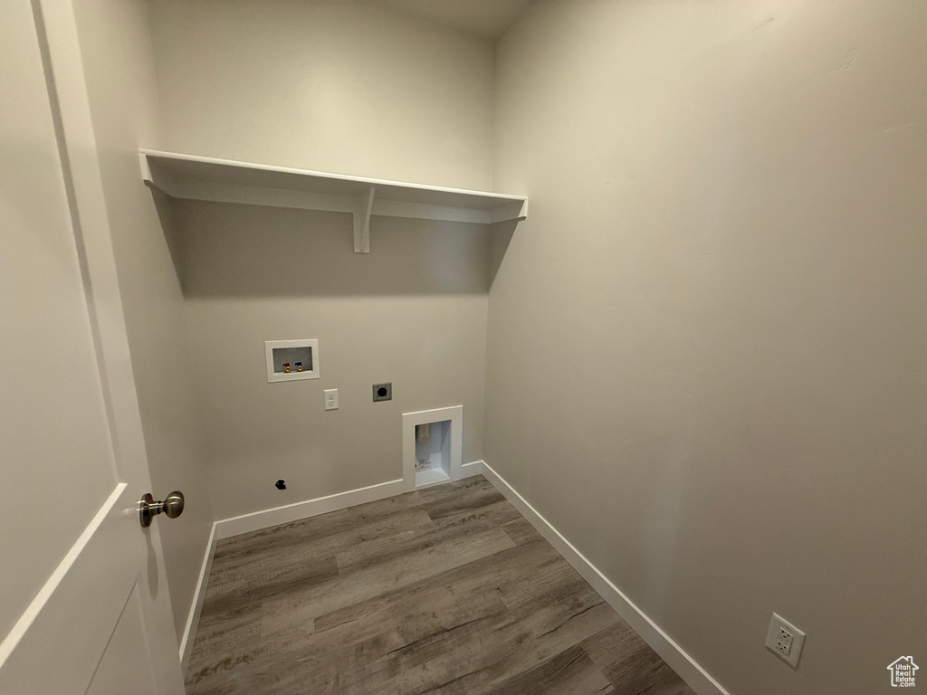 Clothes washing area with laundry area, baseboards, wood finished floors, hookup for a washing machine, and hookup for an electric dryer