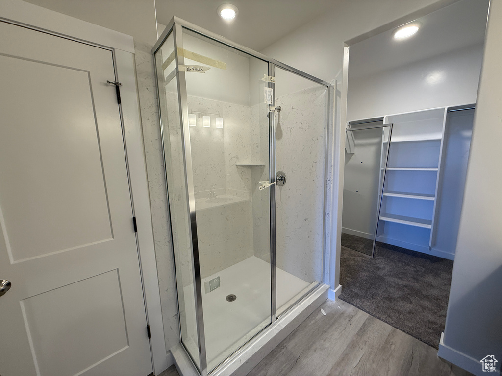 Bathroom with recessed lighting, wood finished floors, and a shower stall