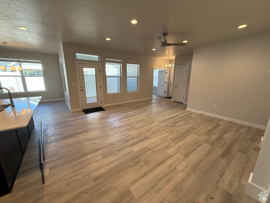 Living area featuring light wood-style flooring, baseboards, and recessed lighting