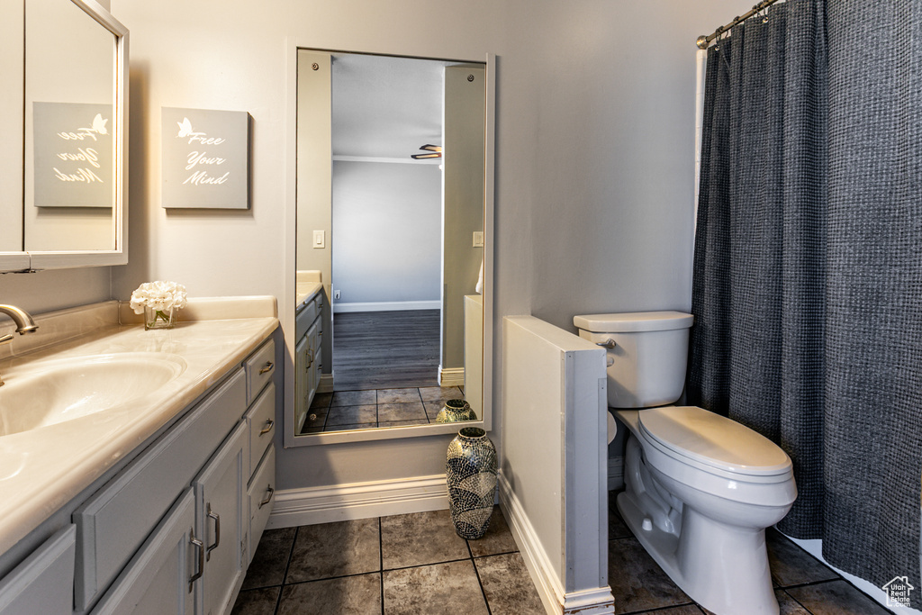 Bathroom featuring baseboards, vanity, toilet, and tile patterned floors