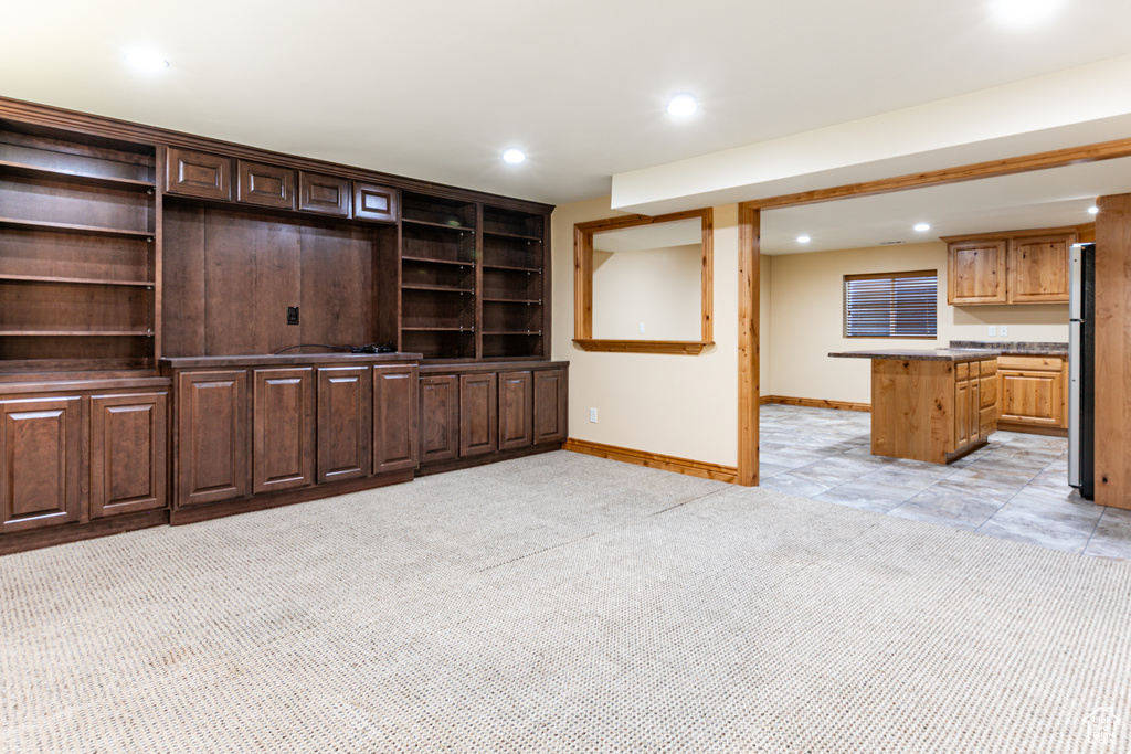Unfurnished living room with light carpet, recessed lighting, and baseboards