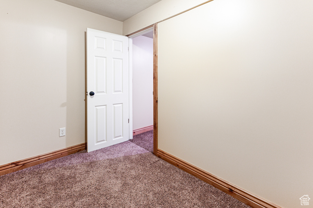 Carpeted empty room featuring baseboards