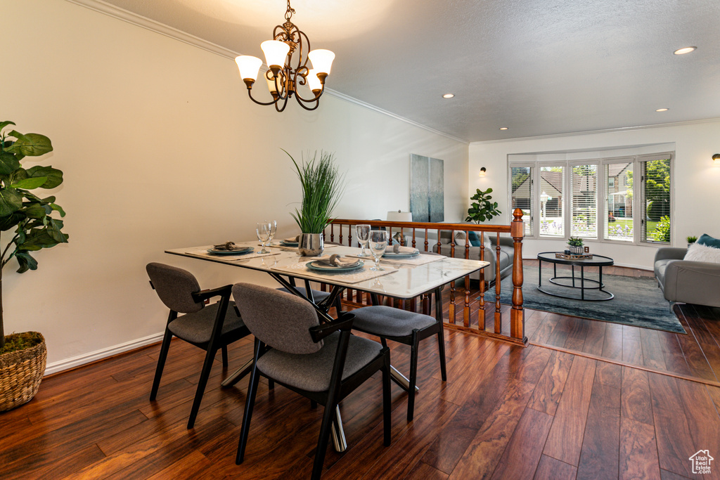 Dining space featuring crown molding, a chandelier, hardwood / wood-style floors, recessed lighting, and baseboards