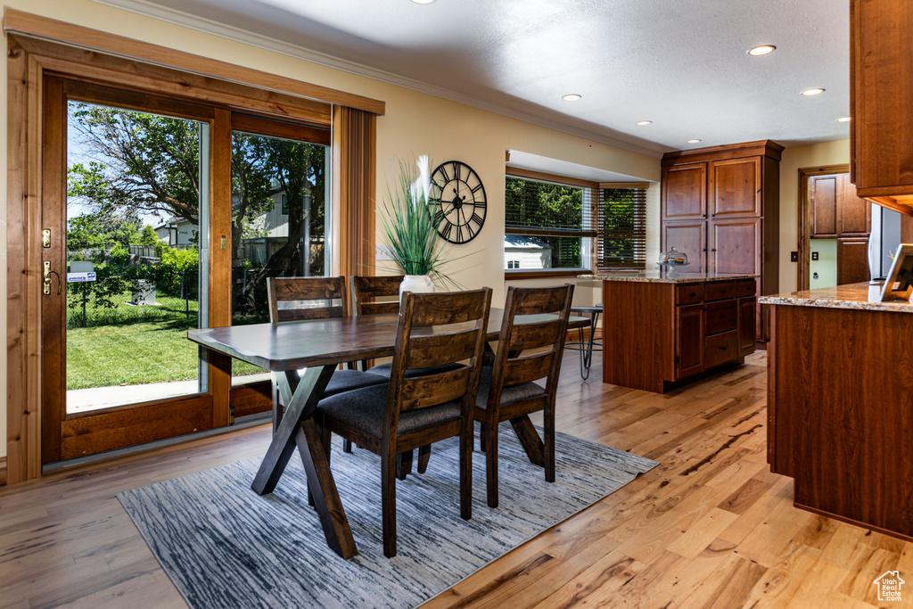 Dining area featuring crown molding, light wood finished floors, and recessed lighting