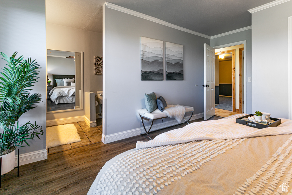 Bedroom with wood finished floors, ornamental molding, and baseboards