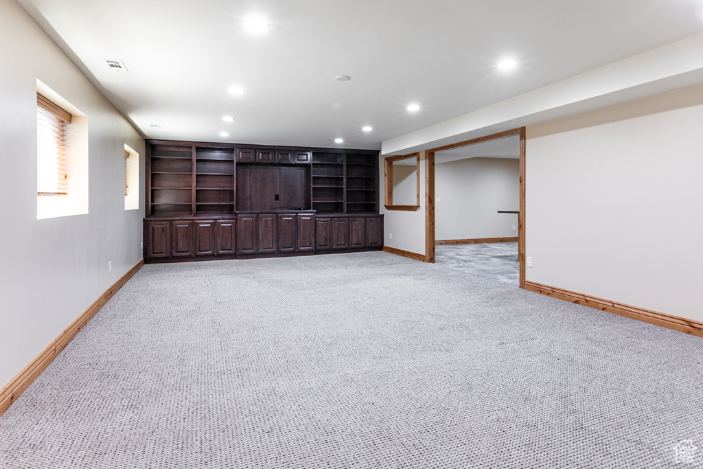Unfurnished living room featuring light carpet, baseboards, and recessed lighting