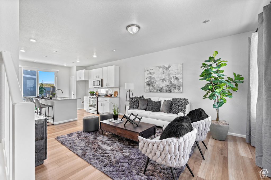 Living area with recessed lighting, baseboards, and light wood finished floors