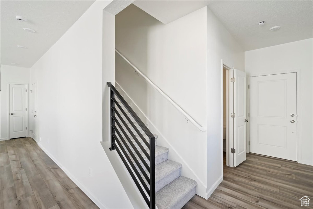 Stairway featuring wood finished floors and baseboards