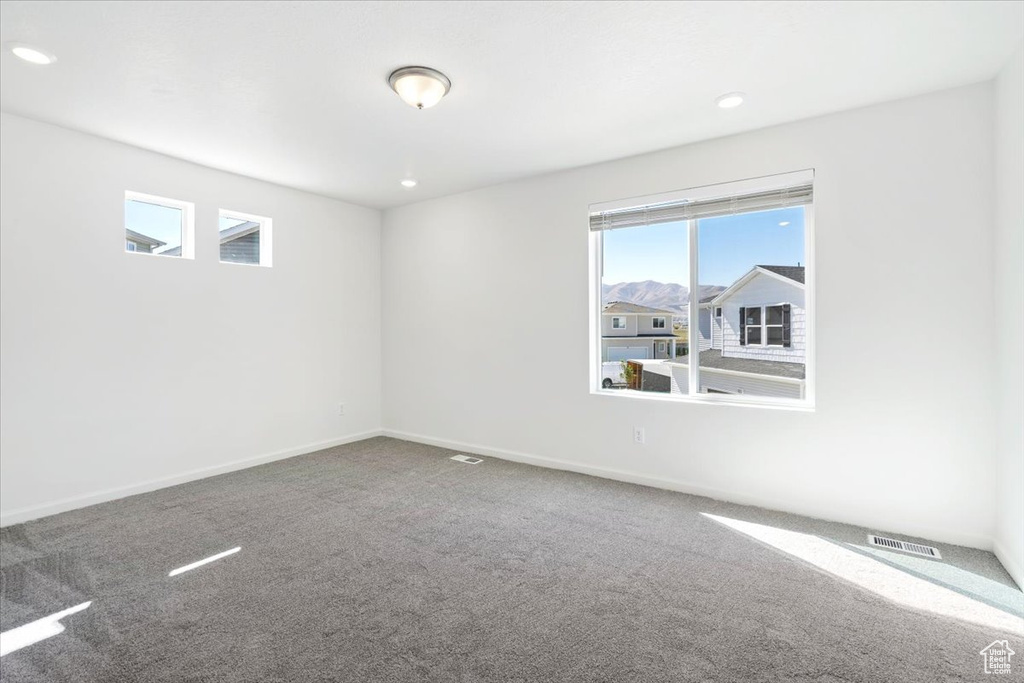 Carpeted spare room with recessed lighting, visible vents, and baseboards