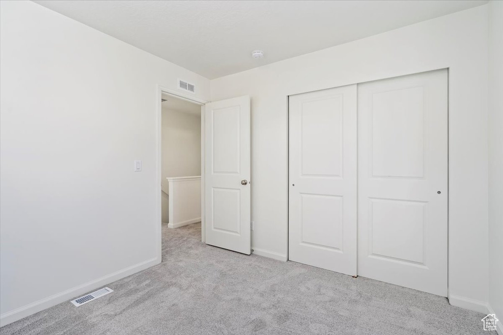 Unfurnished bedroom featuring carpet floors, visible vents, and baseboards