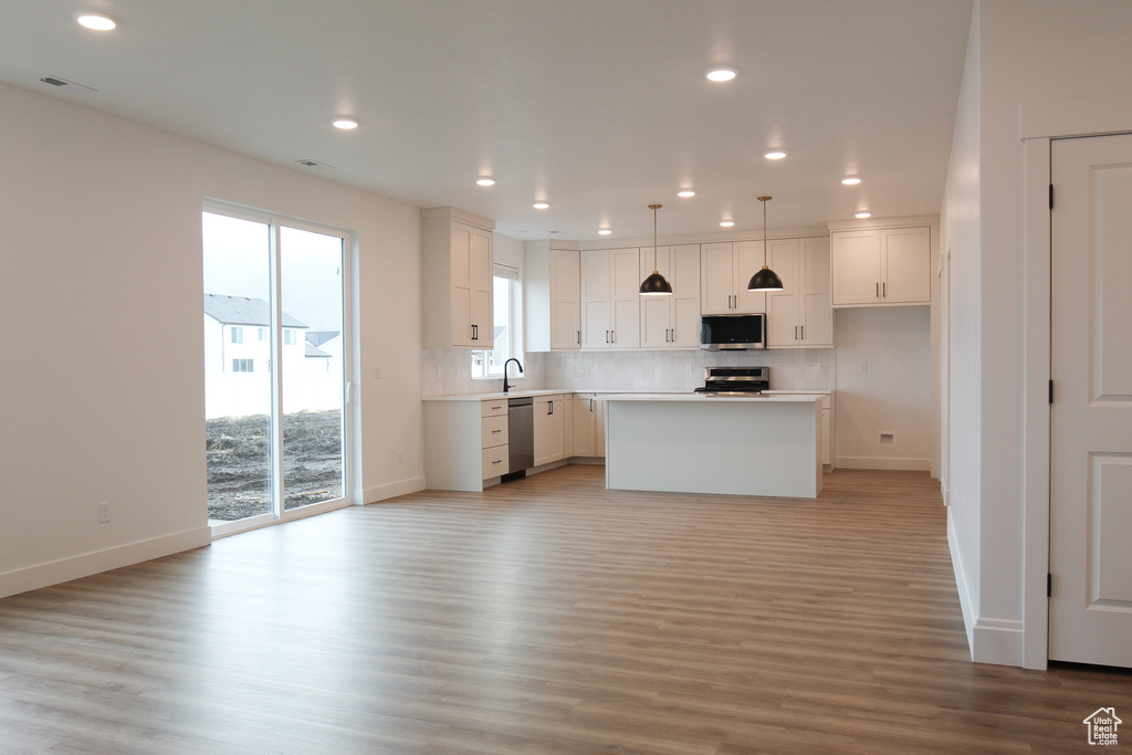 Kitchen with appliances with stainless steel finishes, baseboards, decorative backsplash, plenty of natural light, and recessed lighting