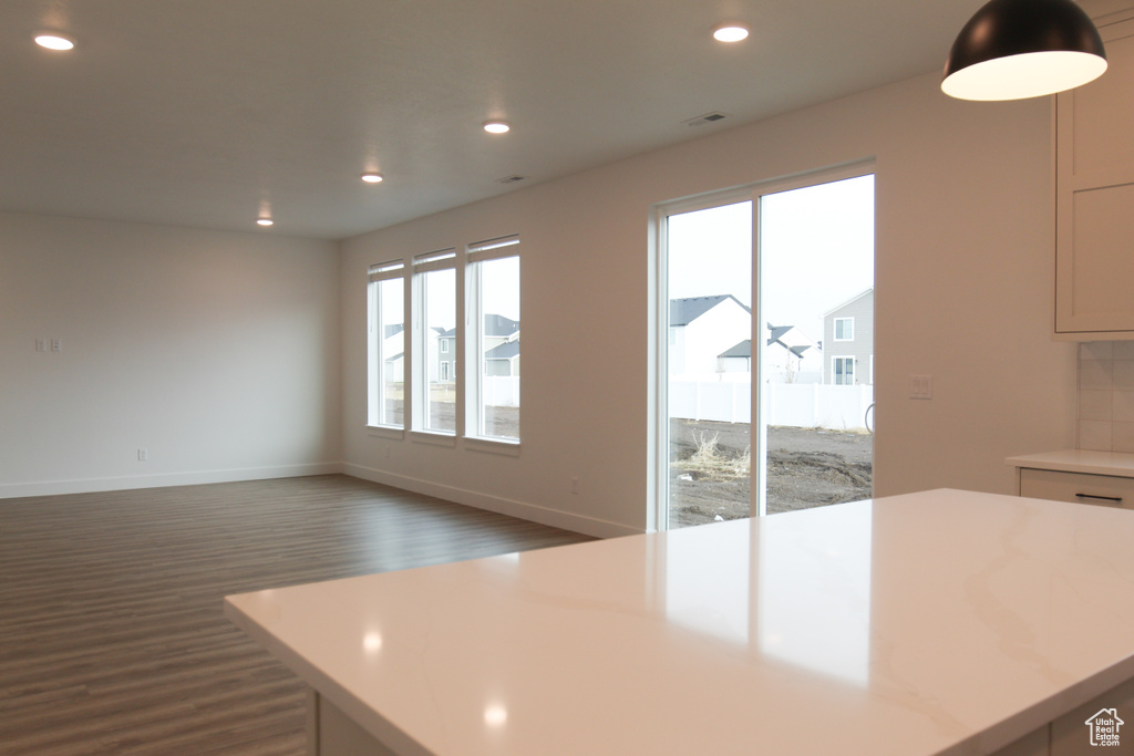 Kitchen featuring dark wood-style flooring, light countertops, recessed lighting, and baseboards