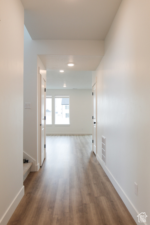 Hallway featuring wood finished floors, baseboards, and recessed lighting