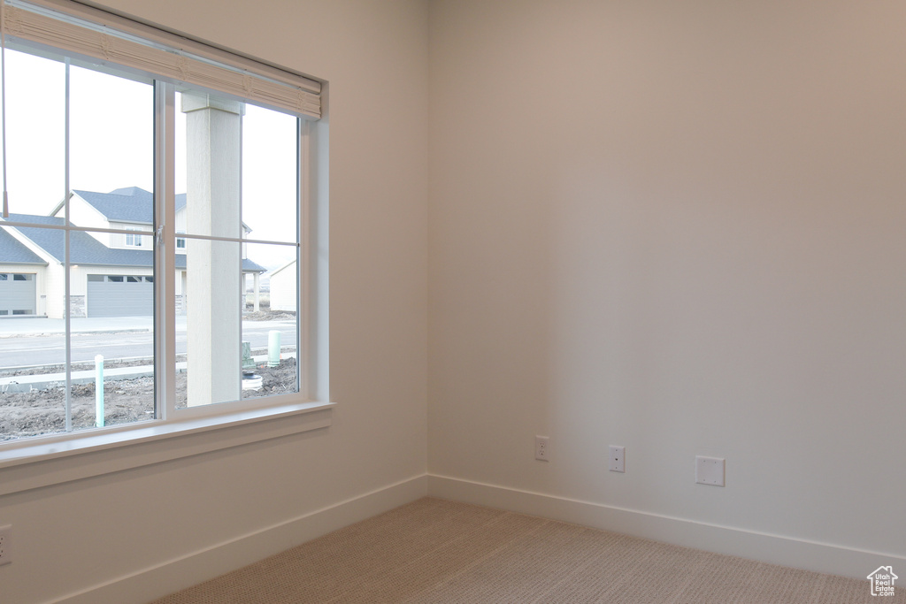 Empty room with plenty of natural light, carpet, and baseboards