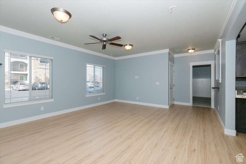 Unfurnished room with crown molding, visible vents, and light wood-type flooring