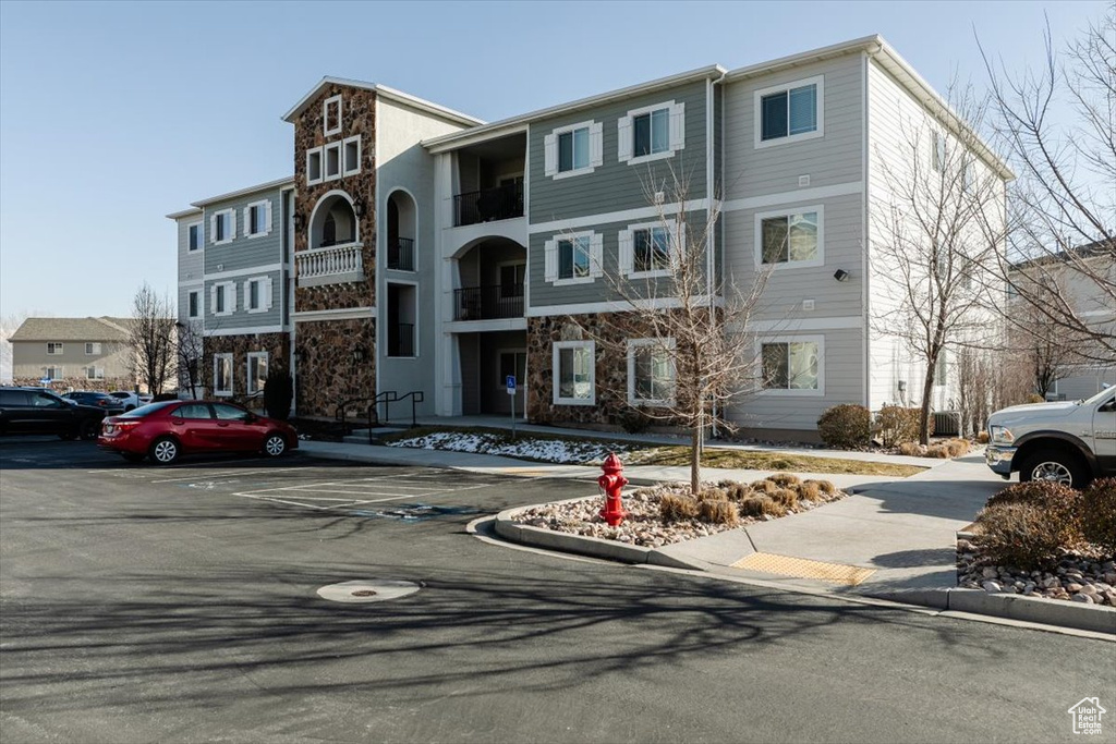 View of property featuring uncovered parking