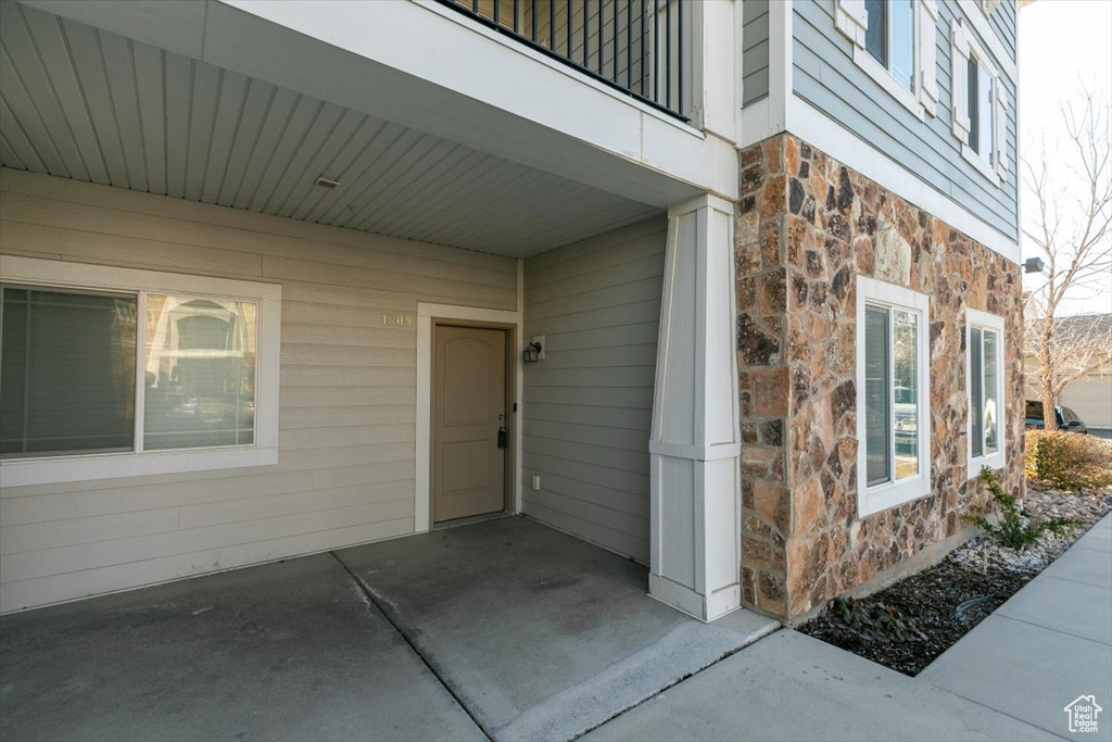 Property entrance with stone siding and a balcony