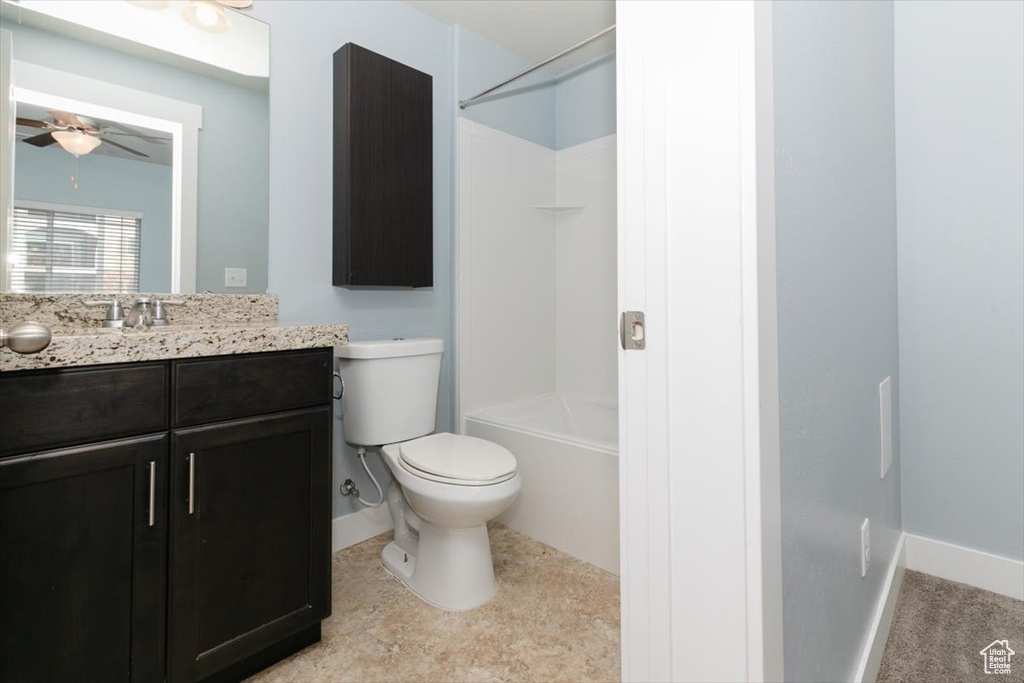 Bathroom featuring toilet, a ceiling fan, washtub / shower combination, baseboards, and vanity