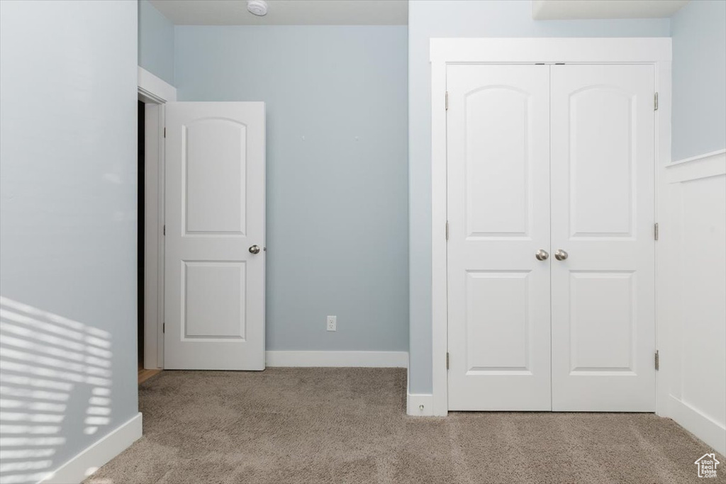 Unfurnished bedroom with a closet, carpet flooring, and baseboards