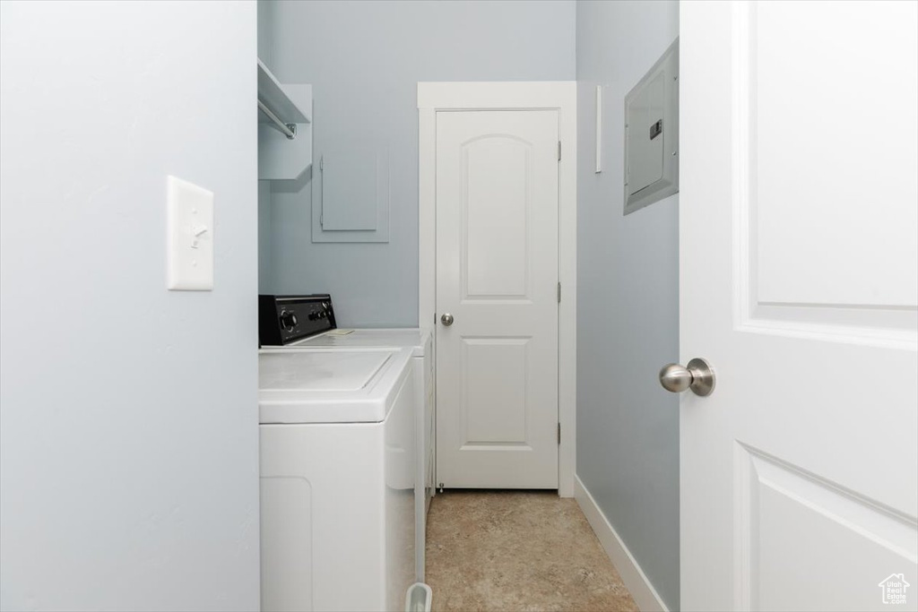 Laundry area with electric panel, baseboards, laundry area, and washing machine and clothes dryer