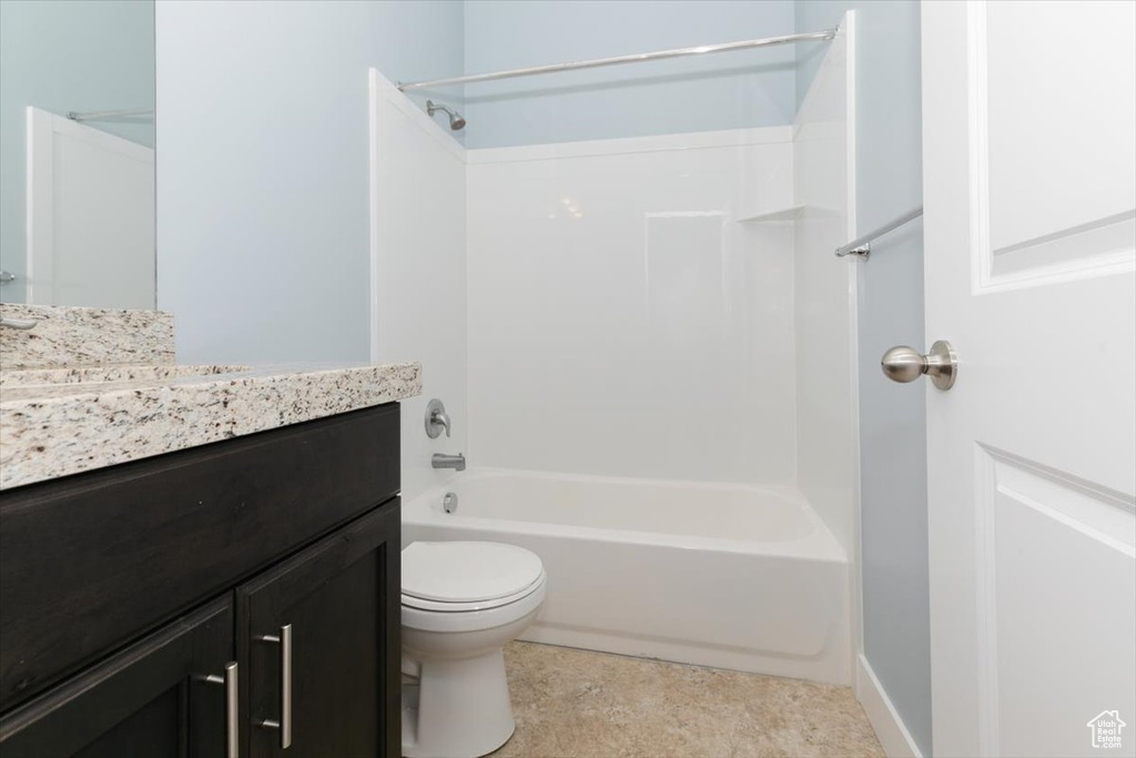 Bathroom featuring shower / bath combination, toilet, and vanity