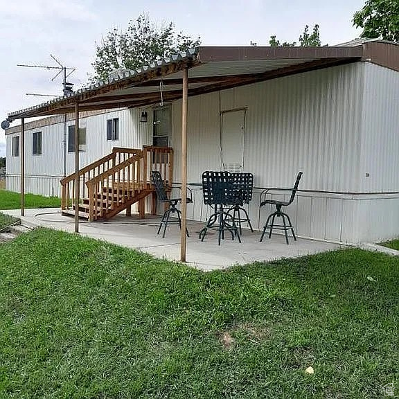 Rear view of property featuring a patio and a yard