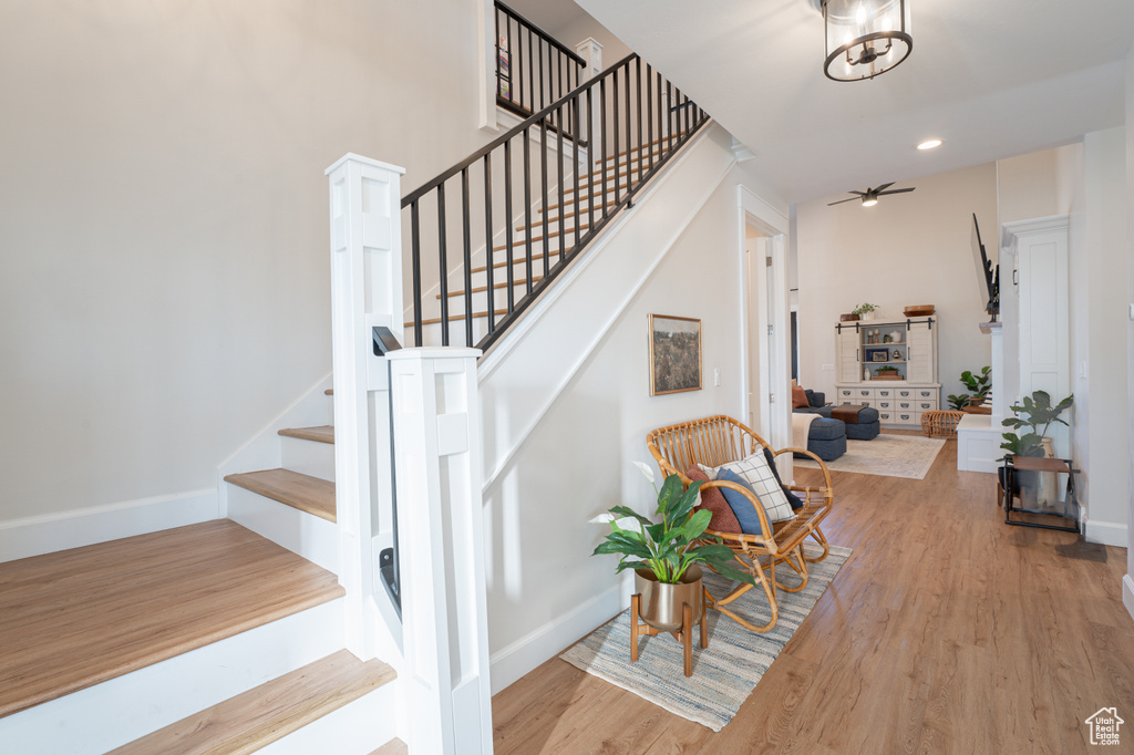 Staircase featuring ceiling fan, baseboards, and wood finished floors
