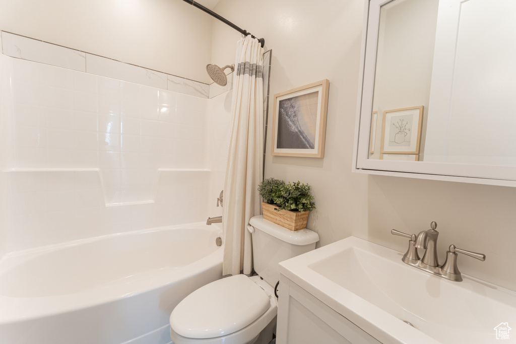 Full bathroom featuring shower / bath combination with curtain, vanity, and toilet