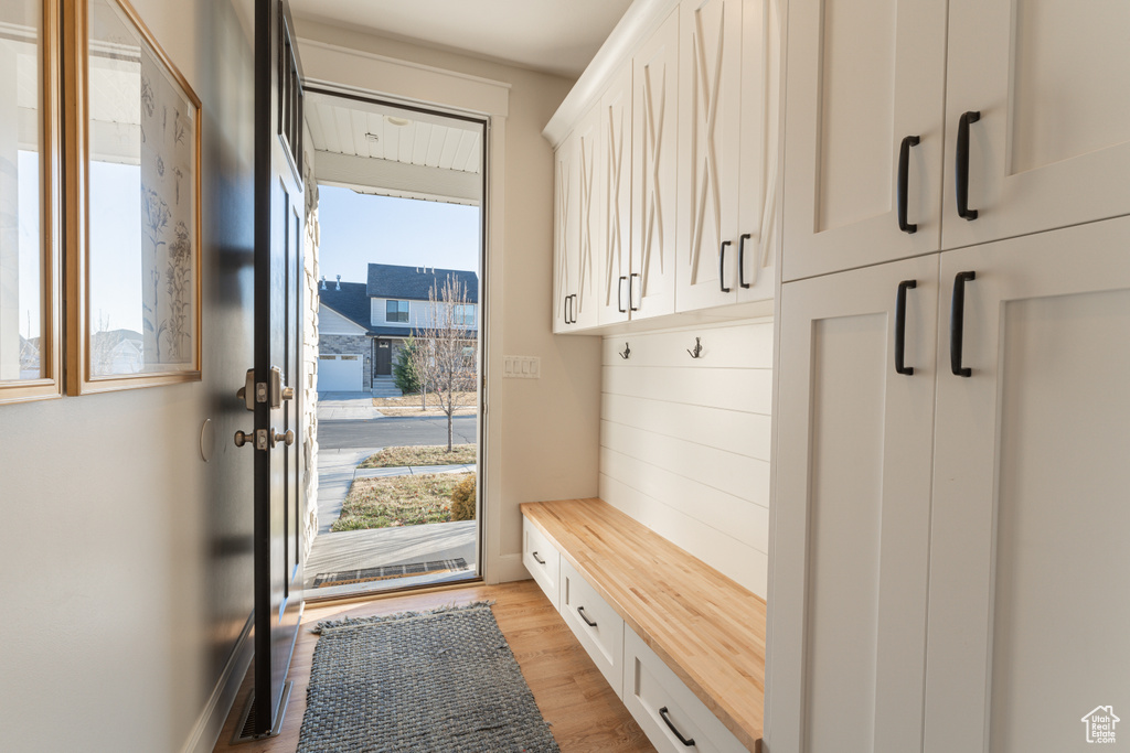 Mudroom featuring light wood-style flooring and baseboards